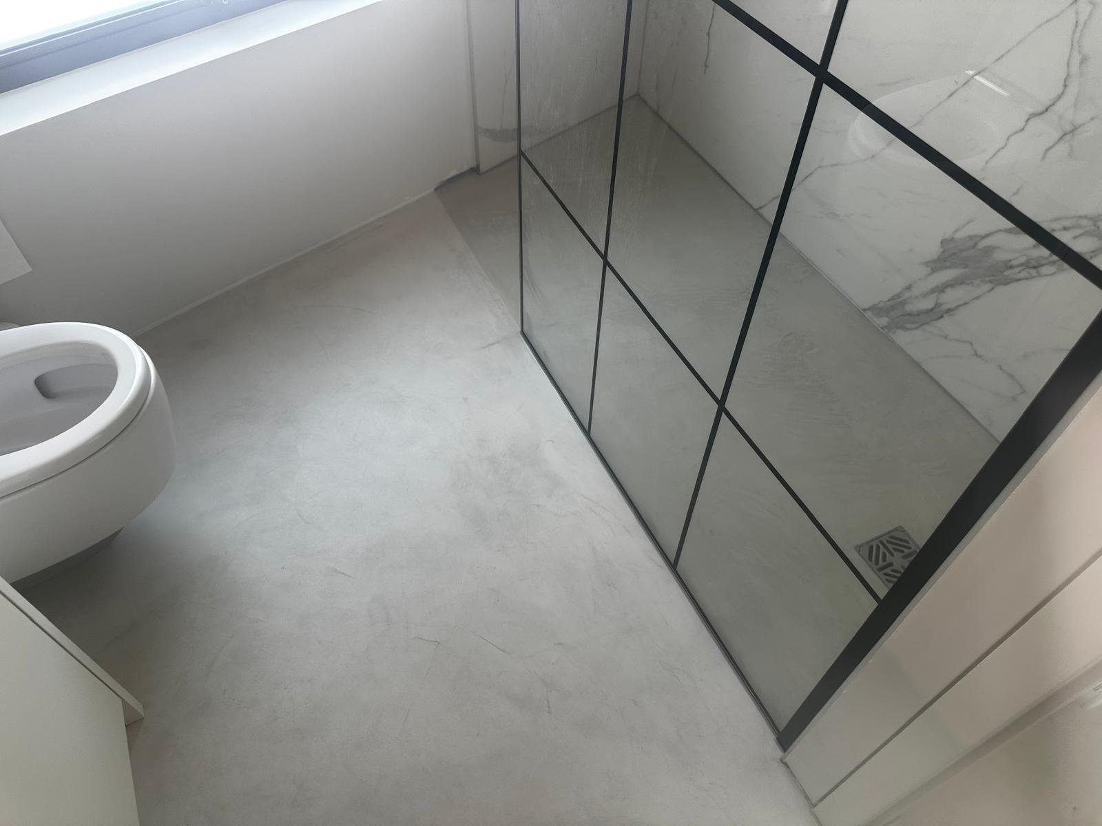 Black grid walk-in shower enclosure with marble tiling